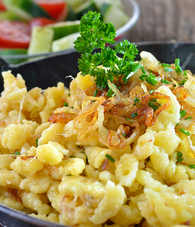 Ein Teller mit einer Portion Essen, begleitet von einer frischen Beilage aus Salat